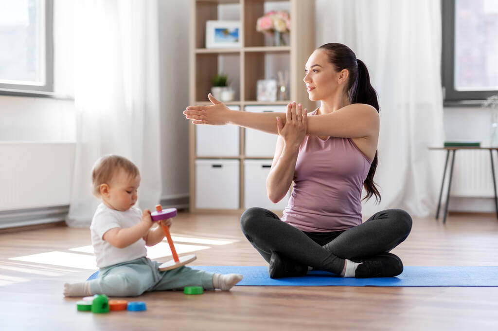 mãe feliz com pequeno bebê se exercitando em casa
 - Foto, Imagem