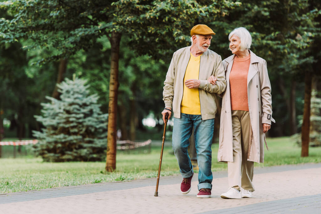 Couple de personnes âgées souriant tout en marchant sur le chemin dans le parc  - Photo, image