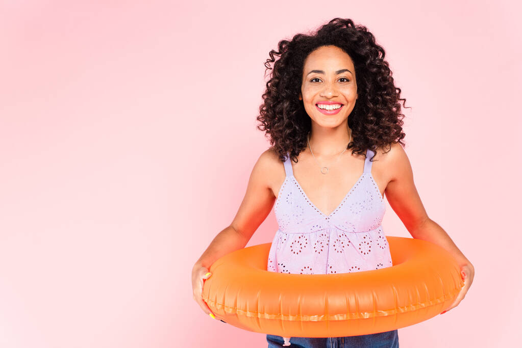 smiling african american woman standing with swim ring isolated on pink  - Photo, Image