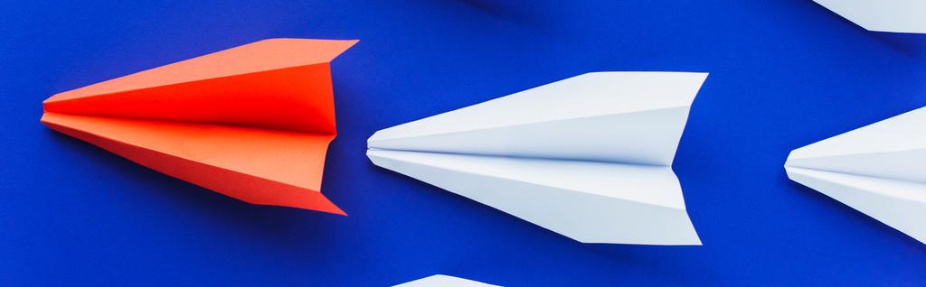 vista superior de aviões de papel branco e vermelho em fundo azul, conceito de liderança, tiro panorâmico
 - Foto, Imagem