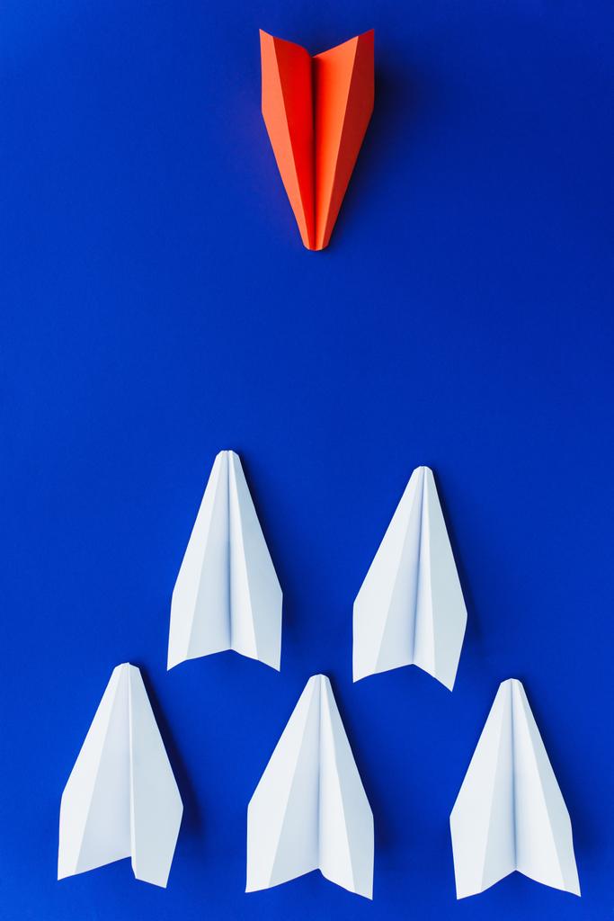 plano con planos de papel blanco y rojo sobre fondo azul, concepto de liderazgo  - Foto, imagen