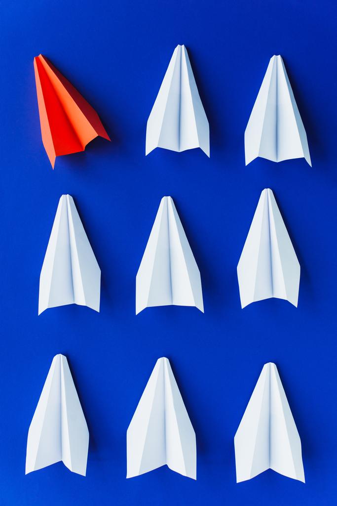 плоский лежал с белыми и красными бумажными плоскостями на синем фоне, концепция лидерства  - Фото, изображение