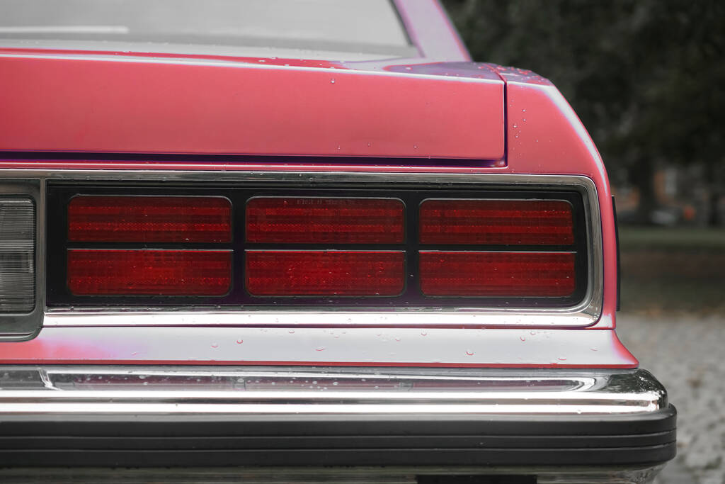 piros vagy rózsaszín vintage autó féklámpája, retro autó lökhárítója, kék szedán hátsó lámpái. Esős idő. őszi szezon - Fotó, kép
