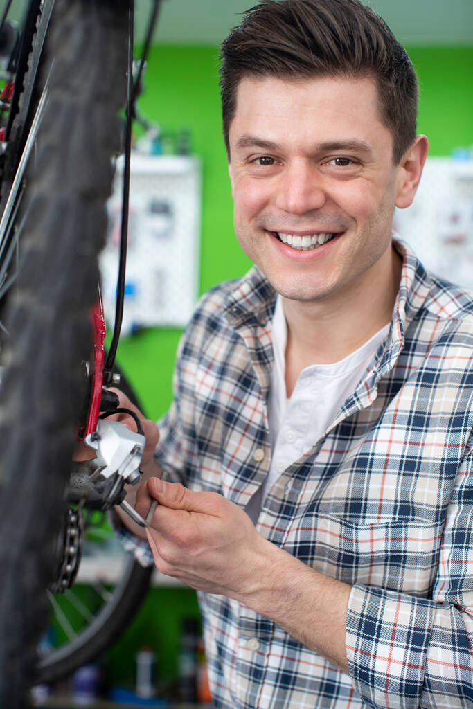 Portret mężczyzny Właściciel małego biznesu Naprawa kół zębatych w warsztacie rowerowym - Zdjęcie, obraz