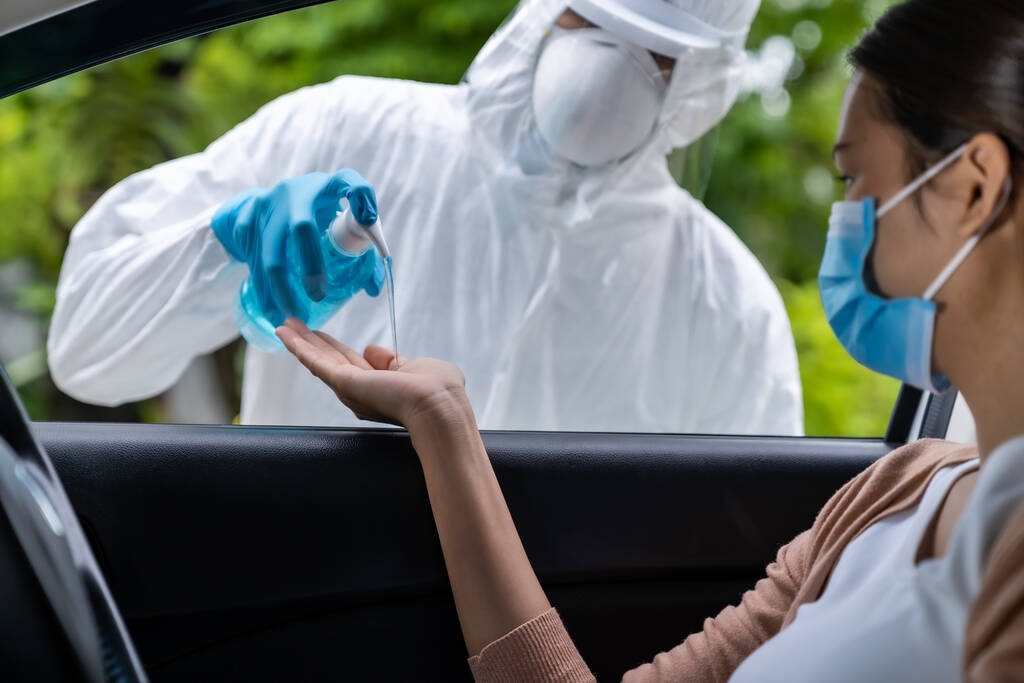 Lékařský personál dát alkohol gel dezinfekci rukou asijské ženy před coronavirus covid-19 test na řídit přes stanice v nemocnici. Nový normální zdravotní pohon přes služby a lékařské koncepce. - Fotografie, Obrázek