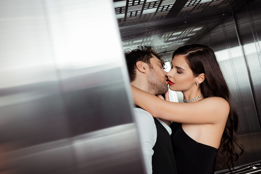 選択的焦点の美しいです女性とともに赤い唇接吻ボーイフレンドでエレベーター - 写真・画像