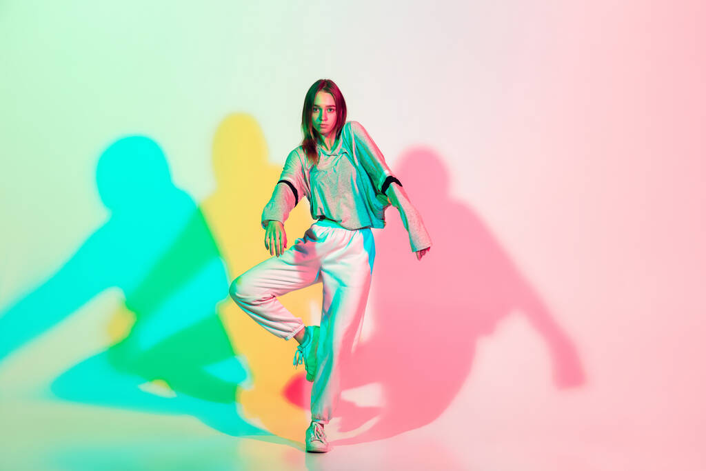 Nuori kaunis nainen tanssii hip-hop, katu tyyli eristetty studion taustalla neon valossa - Valokuva, kuva