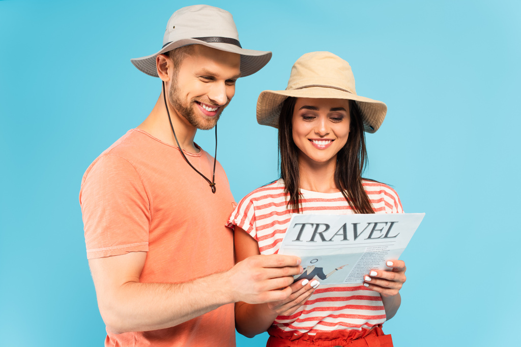 ευτυχισμένο ζευγάρι ανάγνωση ταξιδιωτική εφημερίδα απομονωμένη σε μπλε - Φωτογραφία, εικόνα