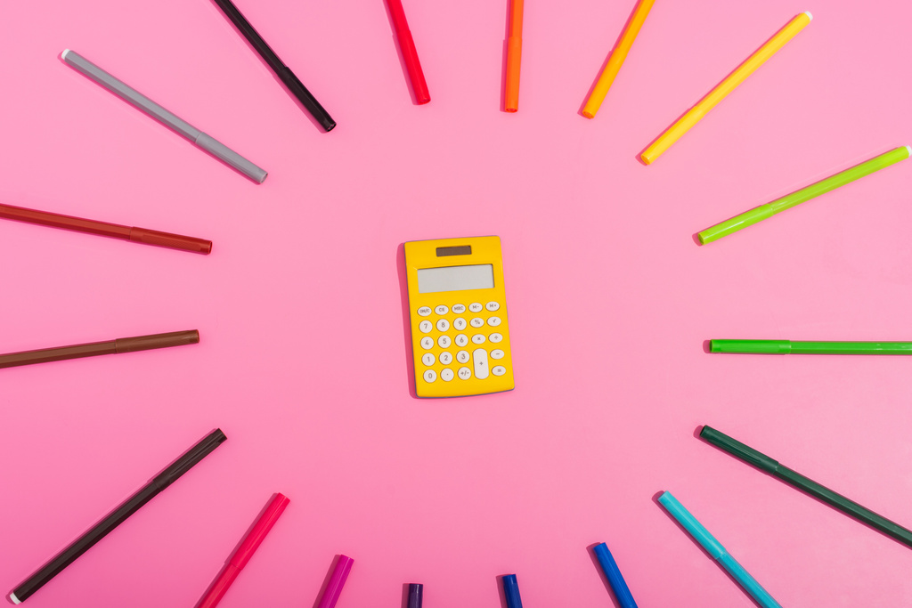 вид сверху калькулятора, обрамлённый цветовыми войлочными ручками на розовый - Фото, изображение