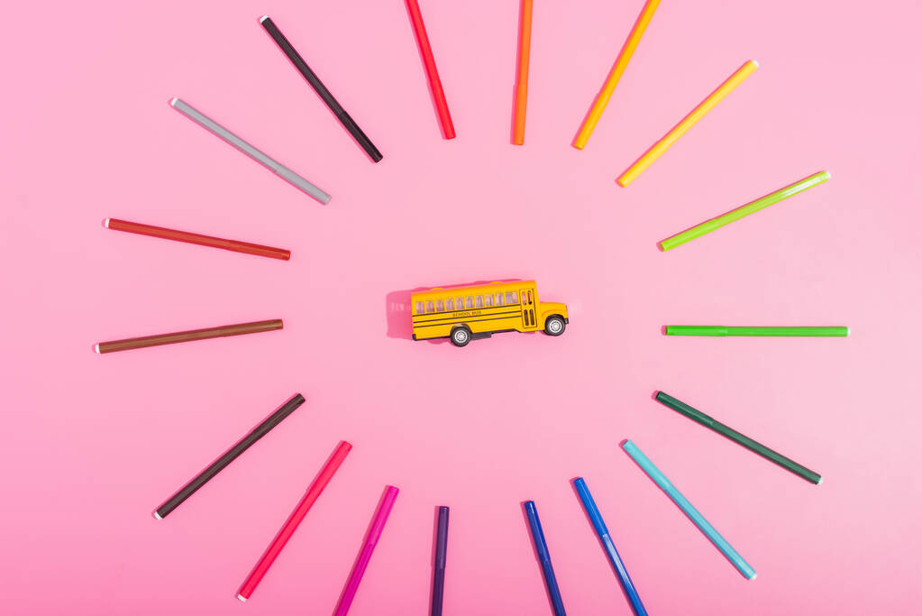 vista dall'alto del modello di scuolabus incorniciato da pennarelli di colore rosa  - Foto, immagini