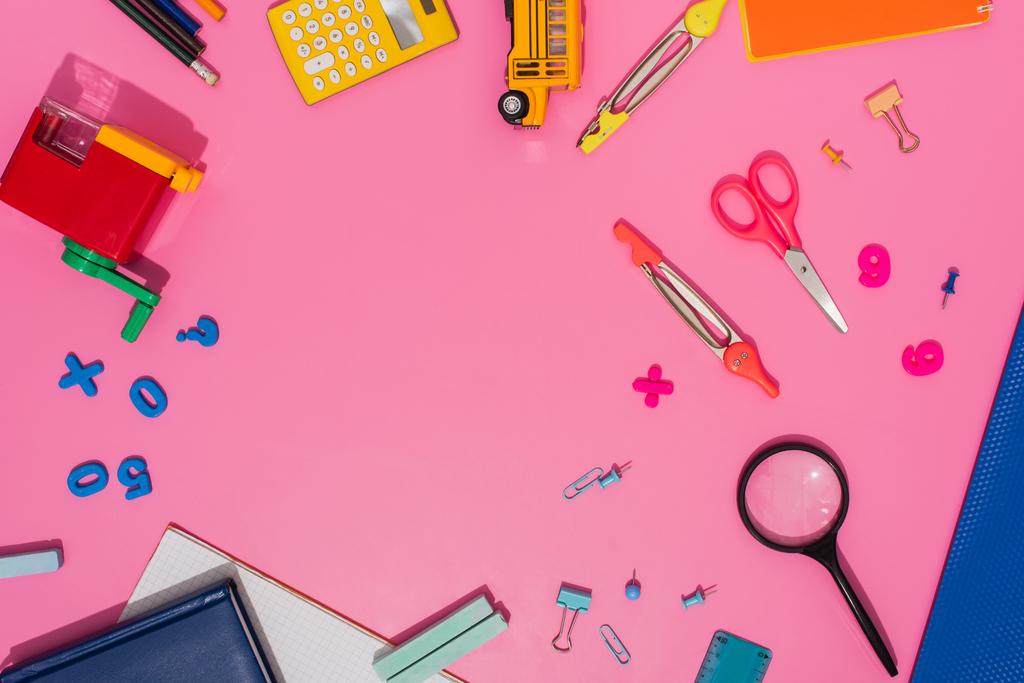 Ansicht von Schulschreibwaren und Schulbusmodell auf rosa mit Kopierraum - Foto, Bild