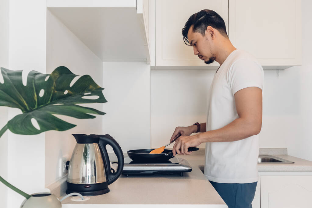 Muž vaří snídani v kuchyni.. - Fotografie, Obrázek