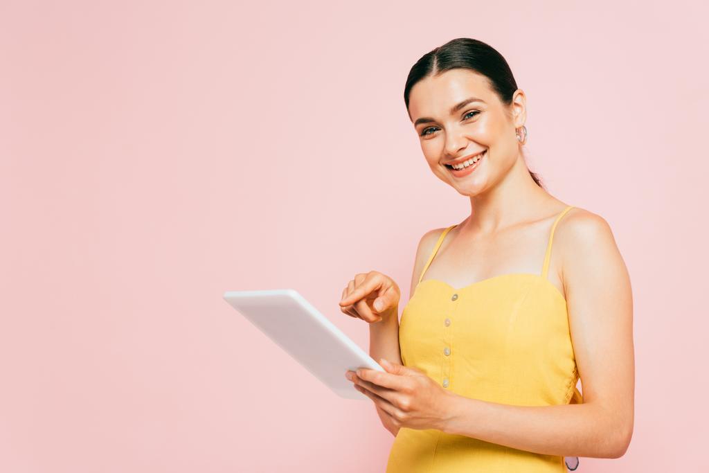 brunette nuori nainen käyttää digitaalista tabletti eristetty vaaleanpunainen - Valokuva, kuva