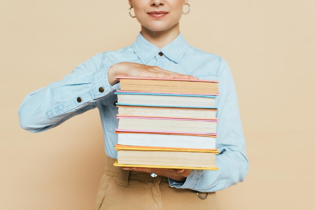 przycięty widok studenta w dżinsowej koszuli z książkami na beżu - Zdjęcie, obraz