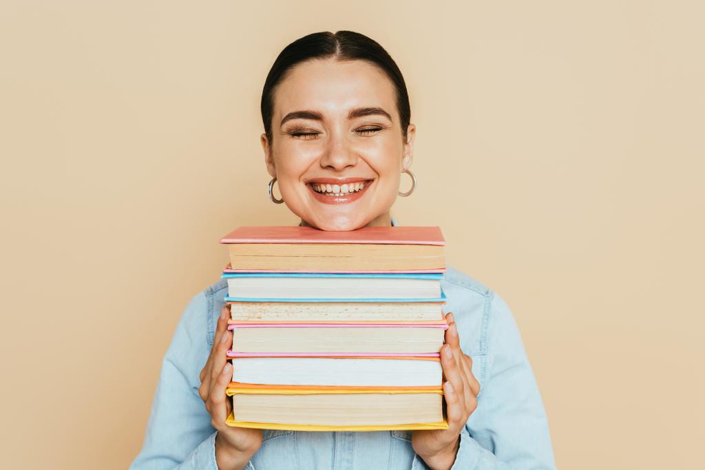 φοιτητής σε denim πουκάμισο με βιβλία χαμογελώντας απομονώνονται σε μπεζ - Φωτογραφία, εικόνα