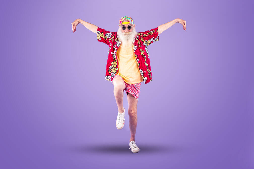 Divatos nagyapa pózol vicces ruhákkal. Senior férfi portrék színes háttér - Fotó, kép