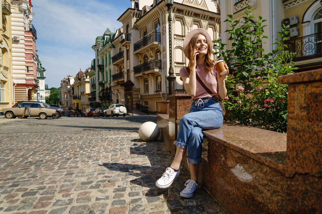 Krásná mladá žena turista s donáškou kávy v centru města mluvit po telefonu - Fotografie, Obrázek