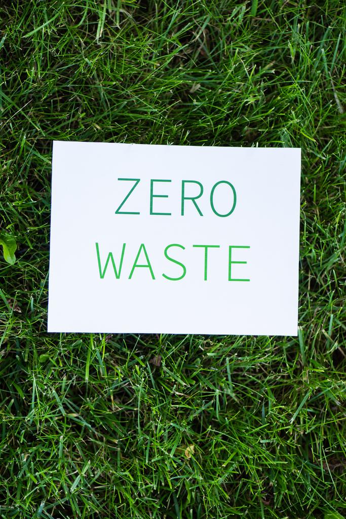 Vista superior do cartão com zero resíduos de palavras na grama, conceito de ecologia
 - Foto, Imagem