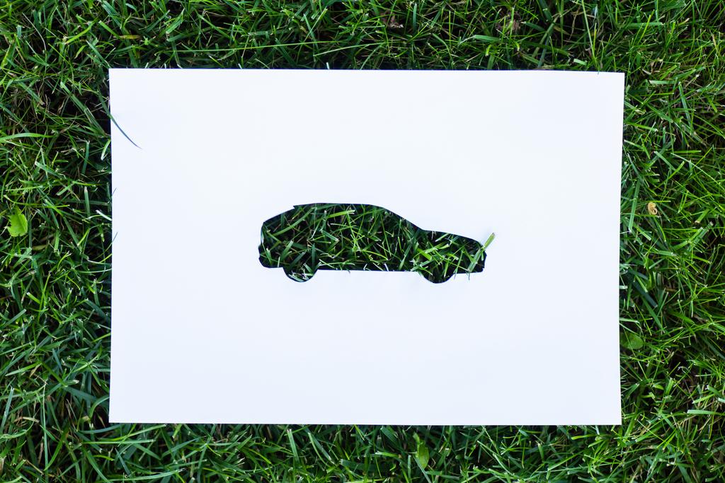 Visão superior do papel com sinal de carro na grama verde, conceito de ecologia
 - Foto, Imagem