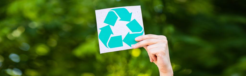 Cultivo panorámico de la tarjeta de retención del hombre con el símbolo de reciclaje al aire libre, concepto de ecología - Foto, imagen