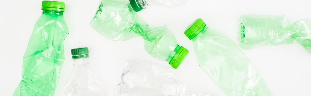 Panoramische oriëntatie van verfrommelde plastic flessen op wit oppervlak, ecologisch concept - Foto, afbeelding