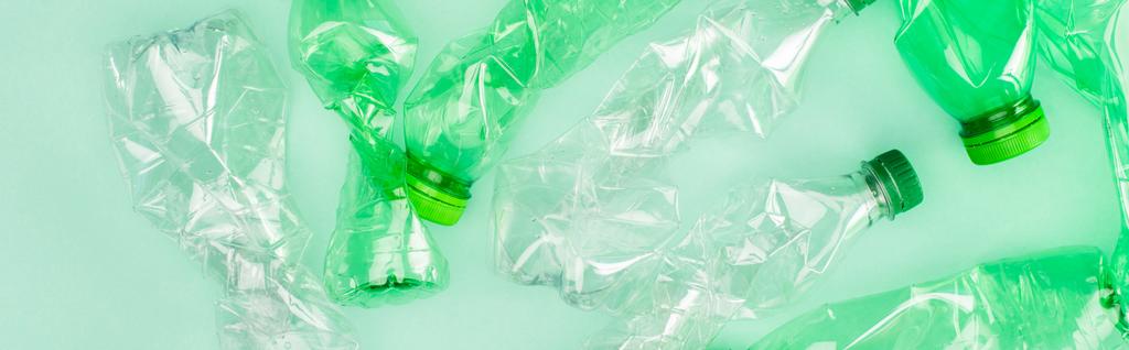 Горизонтальний урожай крихких пластикових пляшок на зеленій поверхні, концепція екології
 - Фото, зображення