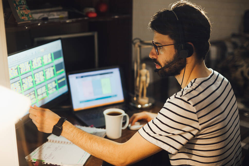 felnőtt szakállas férfi ül otthon íróasztal a számítógép, dolgozik online - Fotó, kép