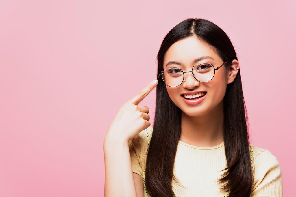 boldog ázsiai lány ujjal mutogatás szemüveget elszigetelt rózsaszín  - Fotó, kép