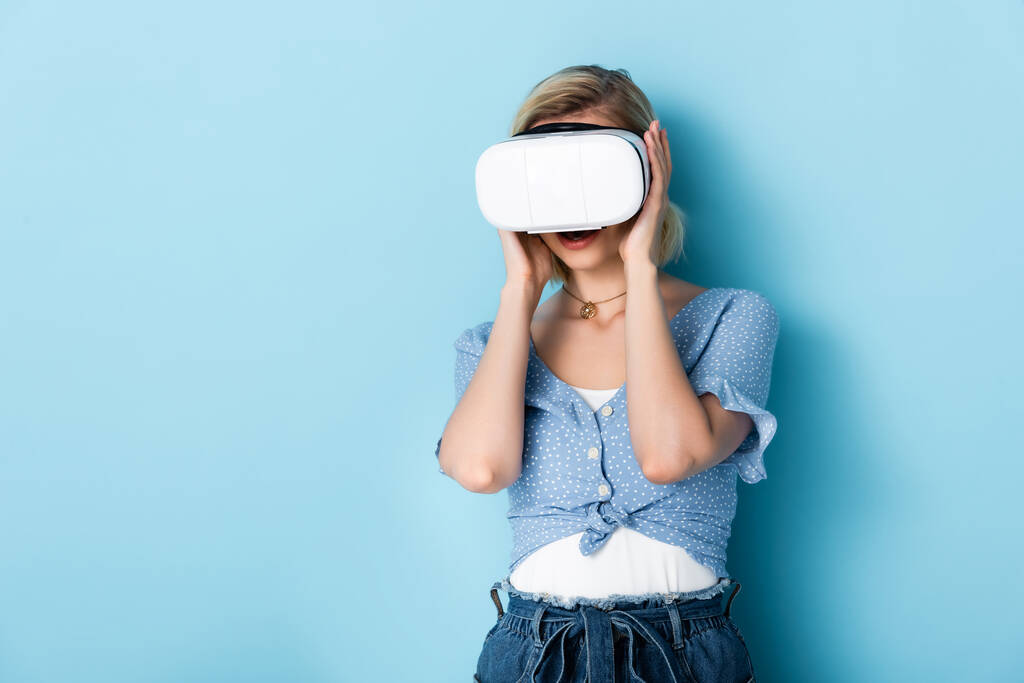 fiatal nő megérinti virtuális valóság headset kék  - Fotó, kép