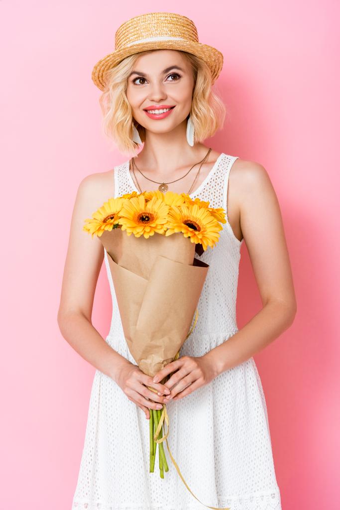 giovane donna in cappello di paglia con fiori gialli su rosa  - Foto, immagini