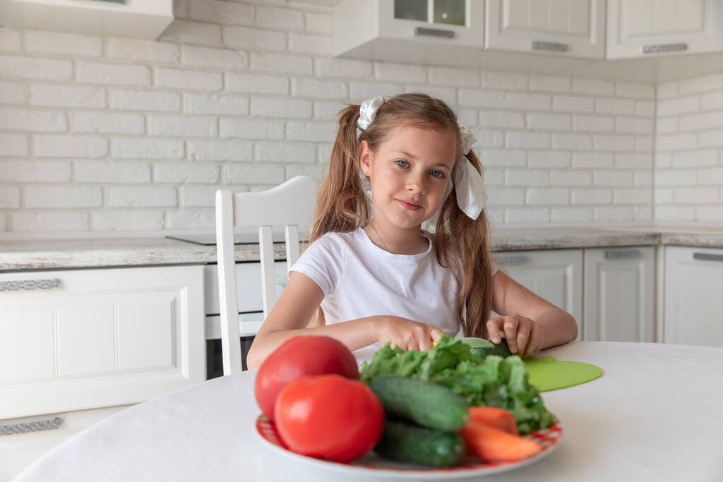 台所で野菜を切る少女。菜食主義 - 写真・画像