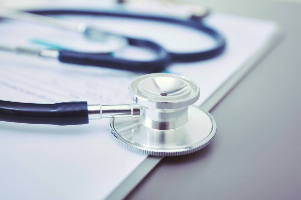 Sprzęt medyczny: niebieski stetoskop i tabletka na białym tle. Sprzęt medyczny - Zdjęcie, obraz
