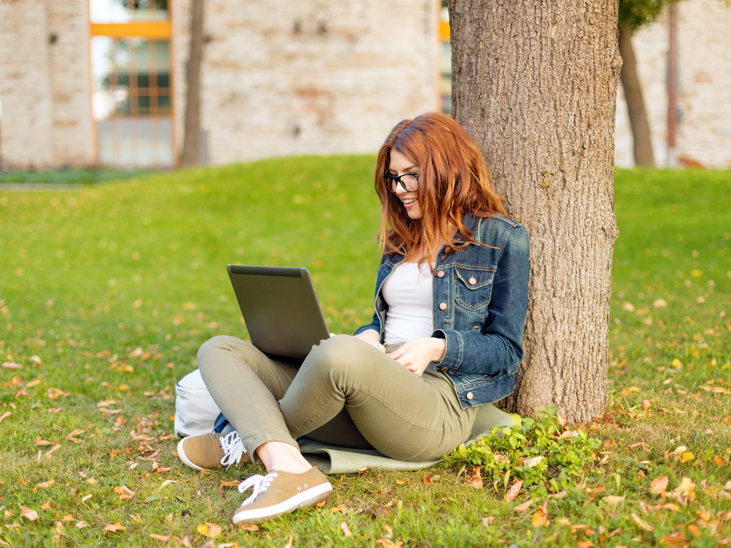 Adolescente sorridente em óculos com laptop
 - Foto, Imagem