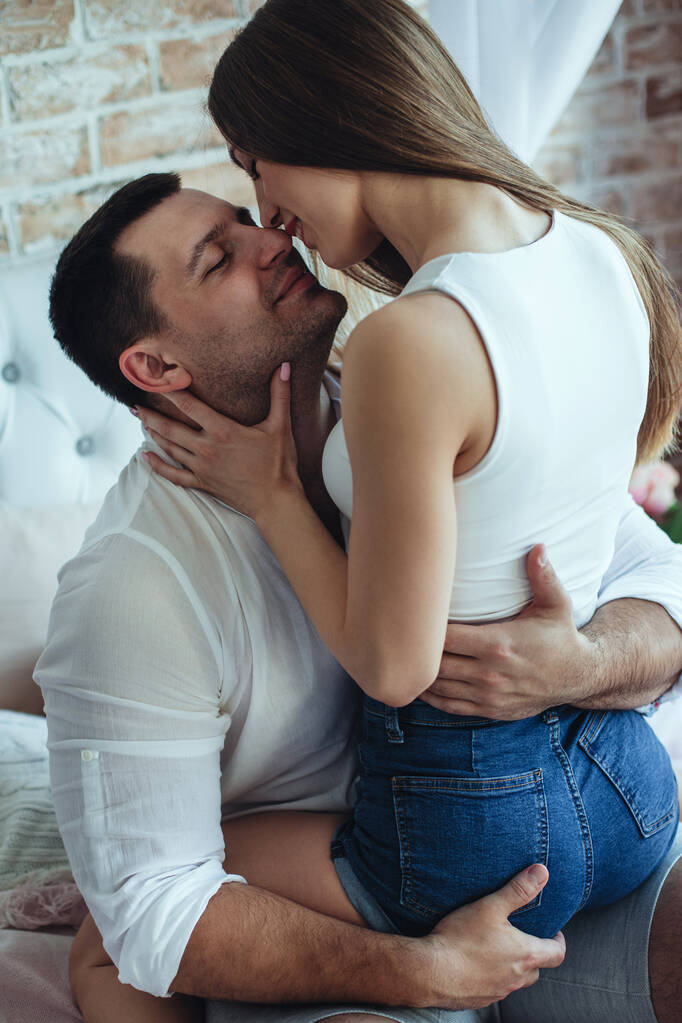 Jeunes amants homme et femme dans la chambre sur le lit. Câlin, baiser. - Photo, image