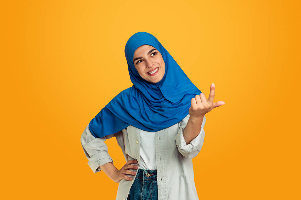 Портрет молодої мусульманки ізольовано на жовтому студійному фоні
 - Фото, зображення