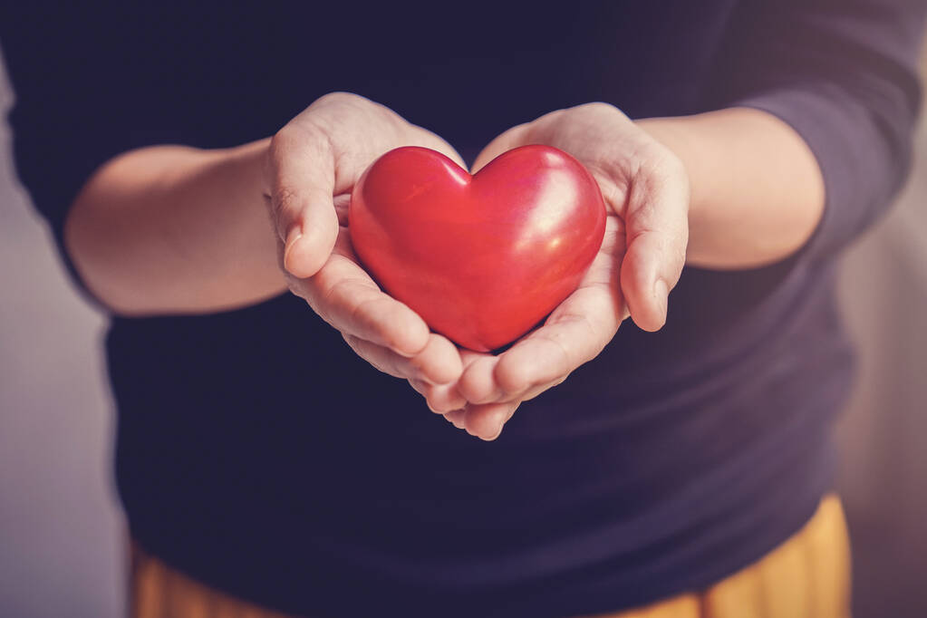 Женщина с красным сердцем, медицинское страхование, пожертвование, счастливая концепция благотворительности добровольцев, Всемирный день психического здоровья, Всемирный день сердца - Фото, изображение
