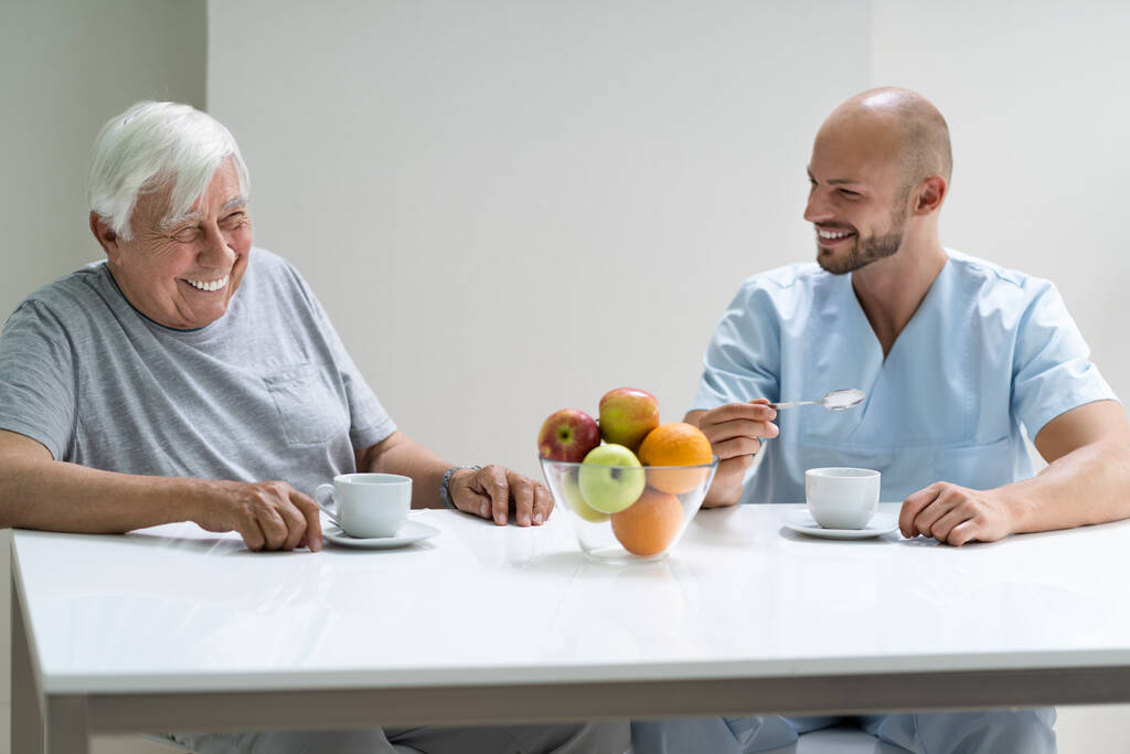 Caretaker in bejaardentehuis met oudere man - Foto, afbeelding