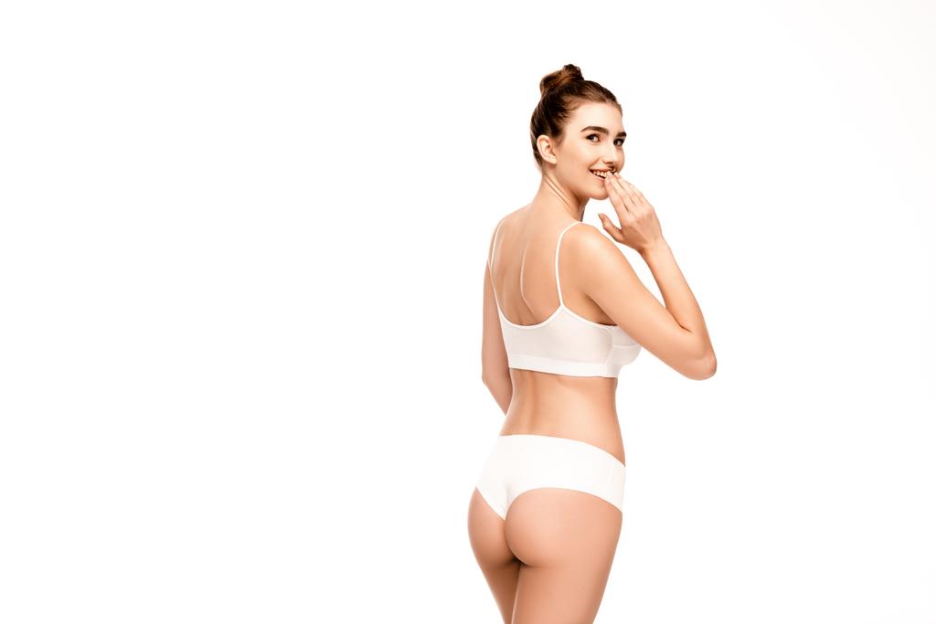 žena s dokonalým tělem v kalhotkách a top stojící a při pohledu na kameru izolované na bílém - Fotografie, Obrázek