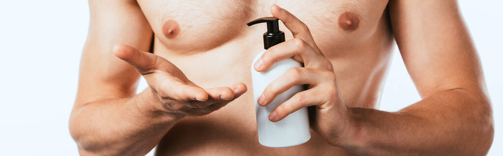 Panoramic shot of muscular man holding bottle of lotion isolated on white - Photo, Image