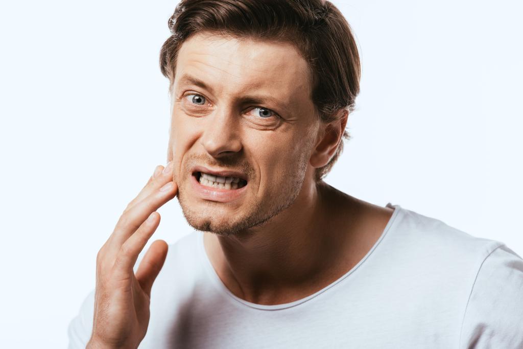 Homme insatisfait touchant la peau sur la joue isolé sur blanc - Photo, image
