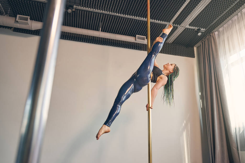 Okouzlující tanečnice ukazující akrobatický výkon na pylonu - Fotografie, Obrázek