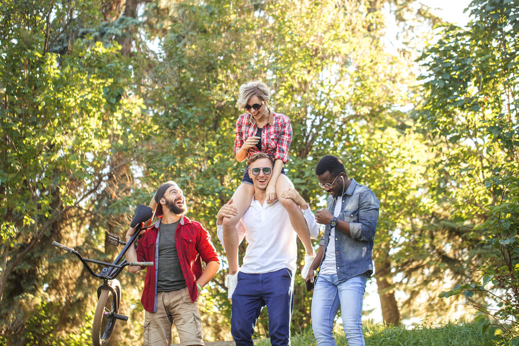 Beste multiethnische Freunde hängen zusammen und spazieren an Sommertagen im Park. - Foto, Bild