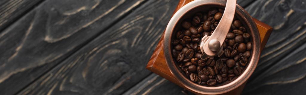 vrchní pohled na vinobraní mlýnku na kávu s kávovými zrny na dřevěném povrchu, panoramatický výstřel - Fotografie, Obrázek