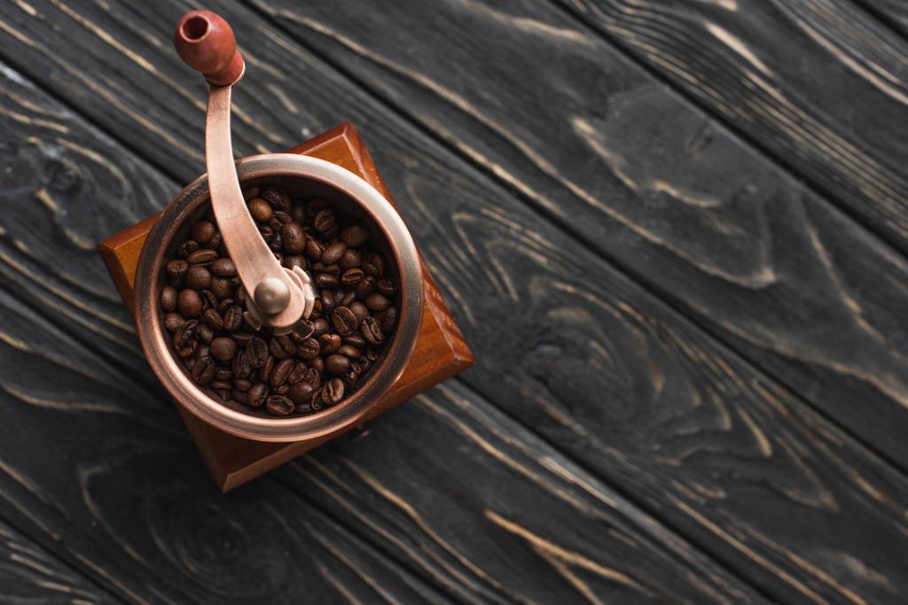 木製の表面にコーヒー豆とヴィンテージコーヒーグラインダーのトップビュー - 写真・画像