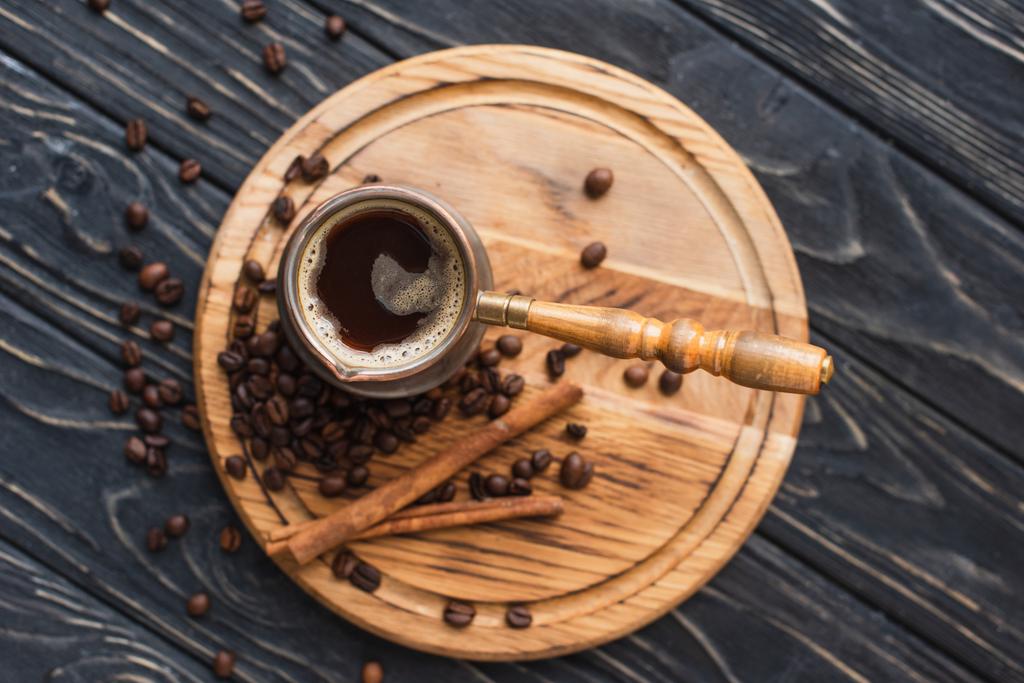 Tahtadaki tarçın çubuklarının yanında kahvenin olduğu en üst manzara. - Fotoğraf, Görsel
