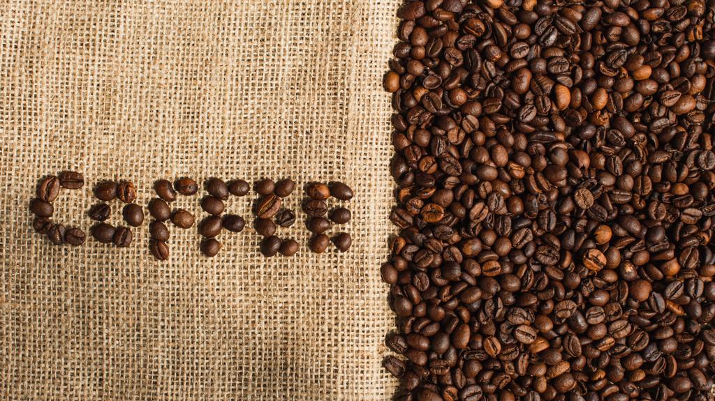 vrchní pohled na kávové písmo z fazolí na pytlovině - Fotografie, Obrázek
