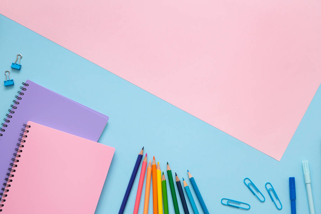 Iskolai koncepció. Lila és rózsaszín notebookok, színes ceruzák, filctollak és gemkapcsok kék háttérrel és másolás helyet rózsaszín háttérrel. Felülnézet. - Fotó, kép