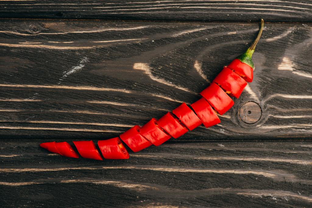 top view of sliced red chili pepper on wooden surface - Photo, Image
