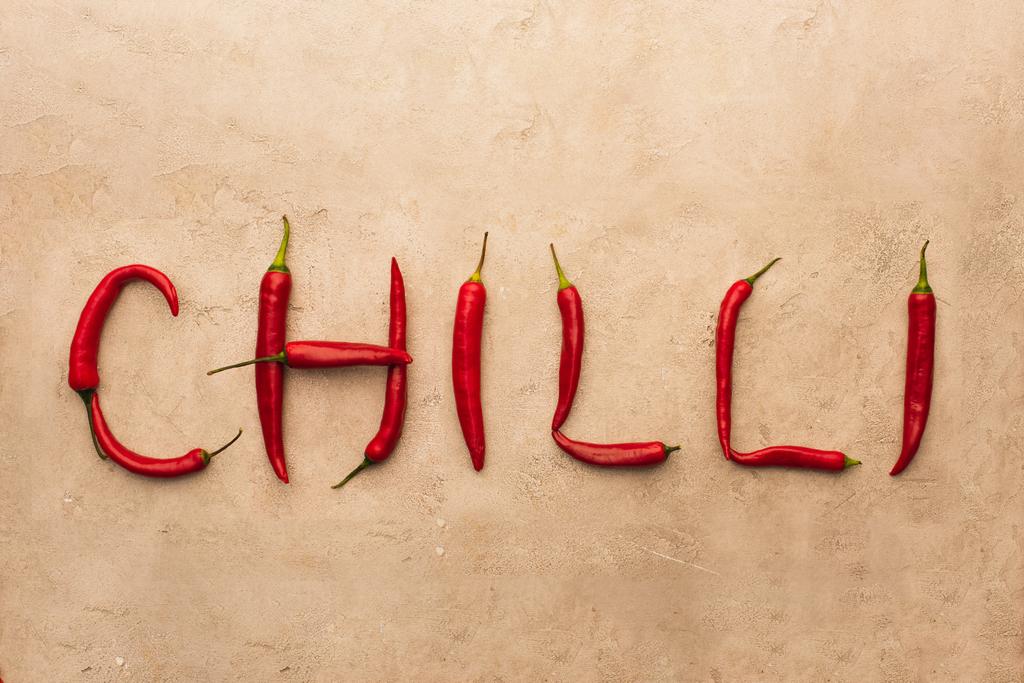 górny widok słowa chili wykonane z papryki na beżowej powierzchni betonu - Zdjęcie, obraz