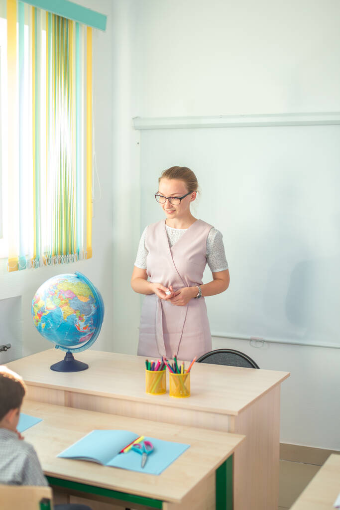 jeune professeur regardant loin au bureau avec globe - Photo, image